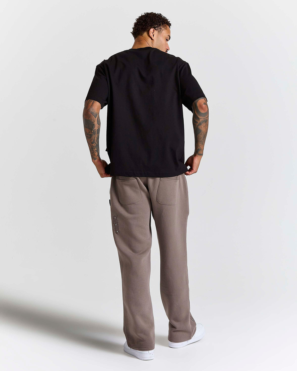 Displays a model wearing the Black 'Hoodrich' branded Inkline V2 Oversized Tshirt