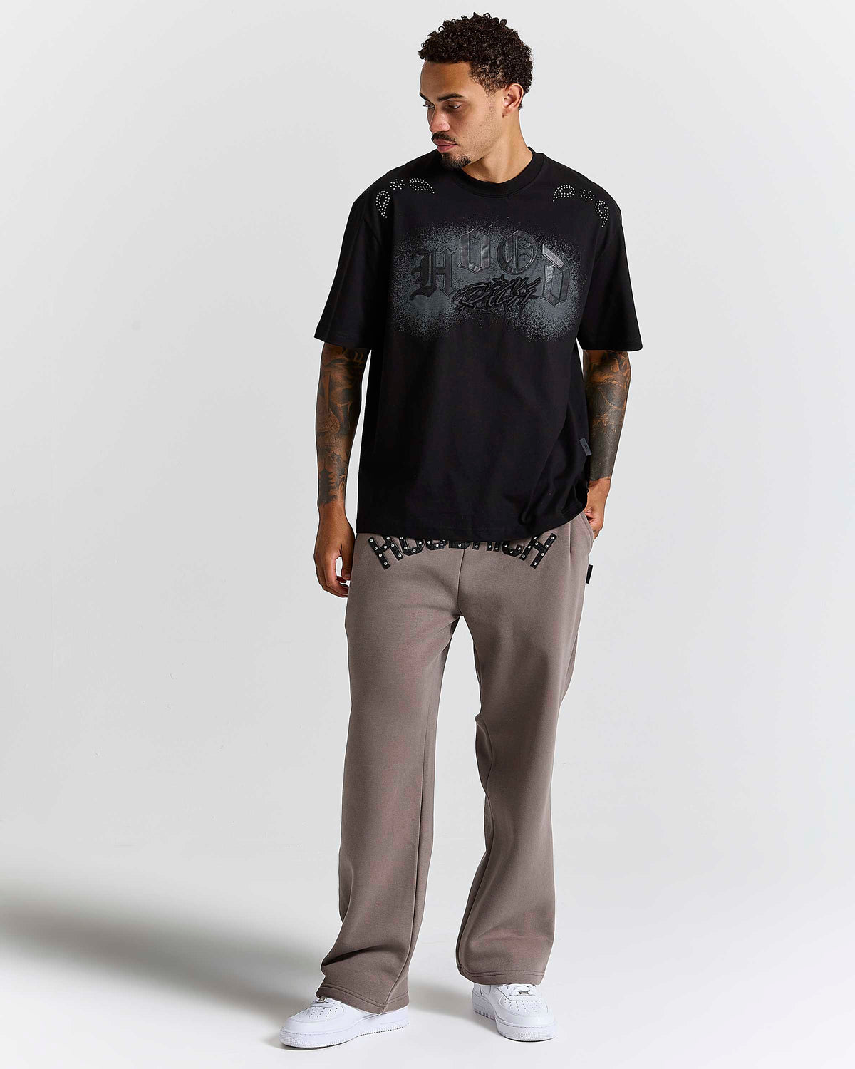 Displays a model wearing the Black 'Hoodrich' branded Inkline V2 Oversized Tshirt