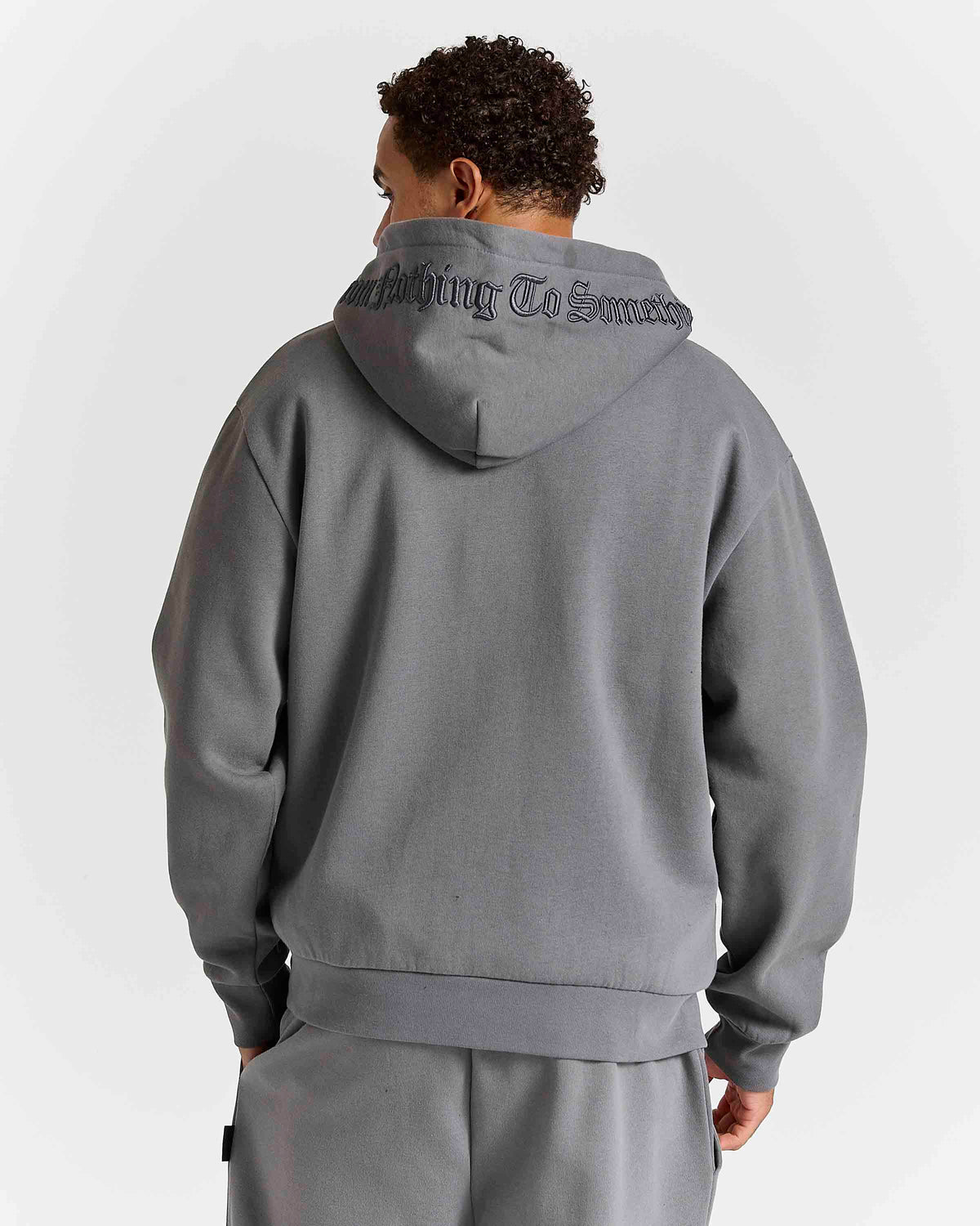 Displays a model wearing the grey lava smoke 'Hoodrich' branded Forza Oversized Zip Through Hoodie