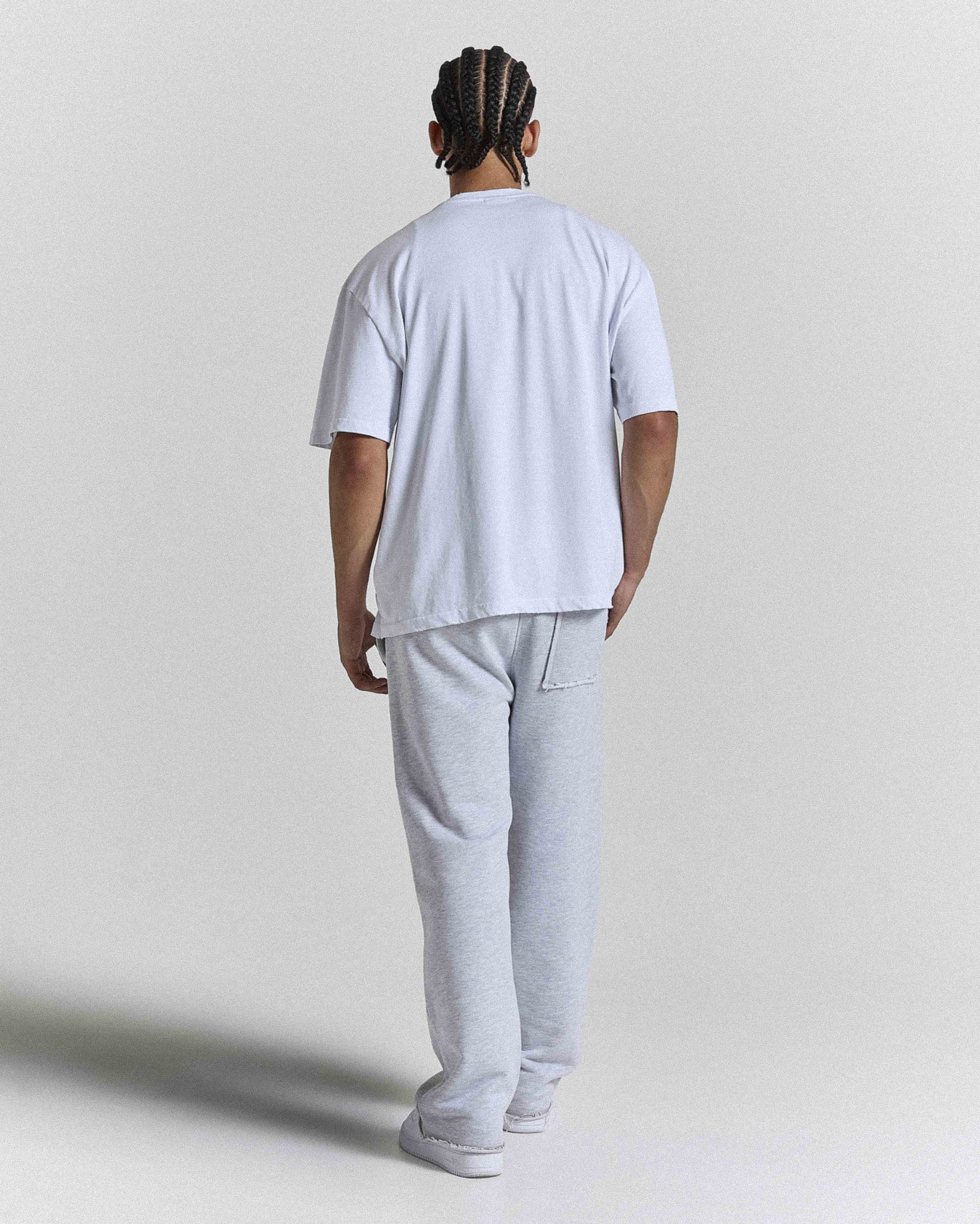 Back view of a male model wearing a regular-fit white Hoodrich t-shirt.