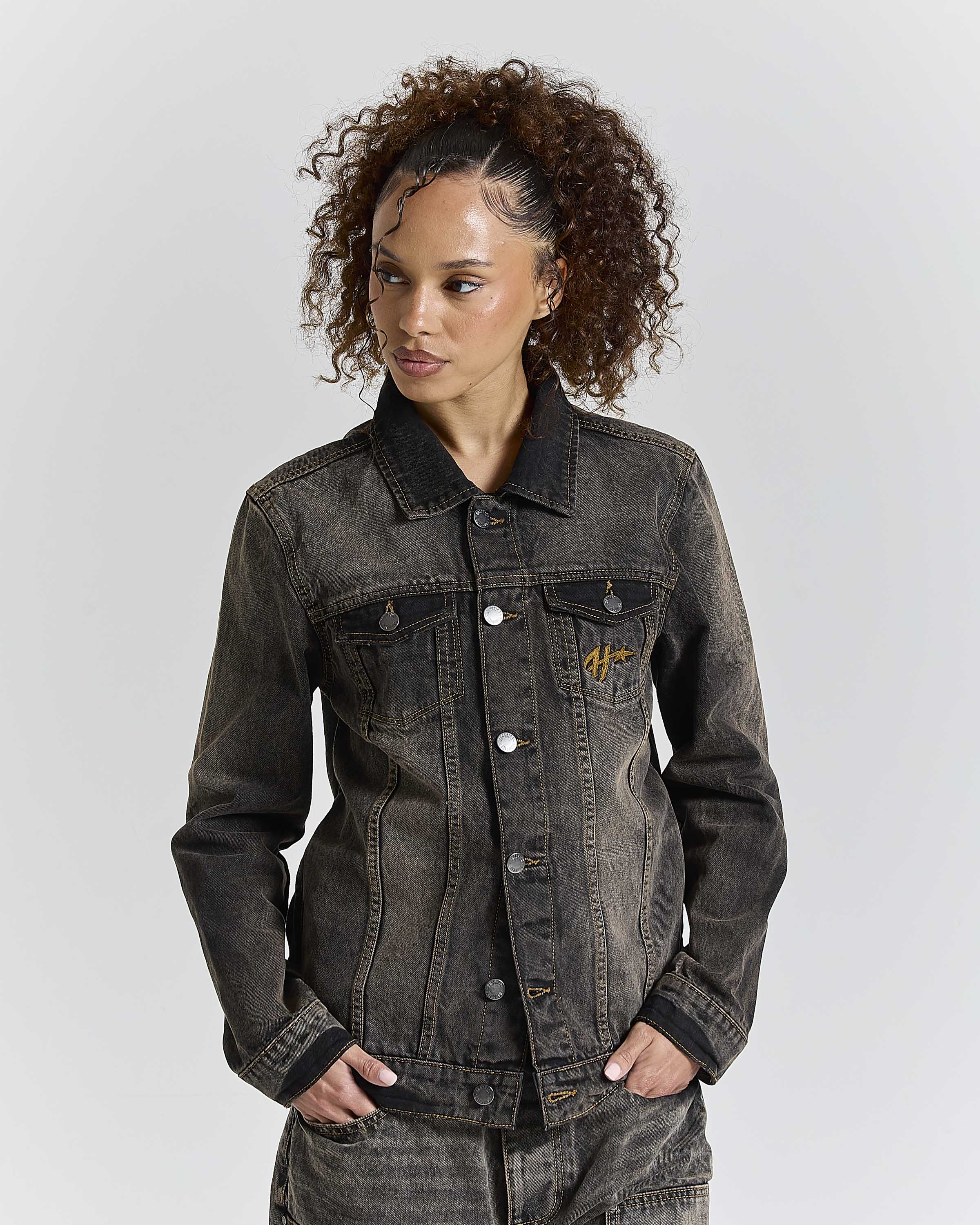 Model wearing a regular fit black rust washed denim jacket with Hoodrich logo embroidery on the chest pocket.