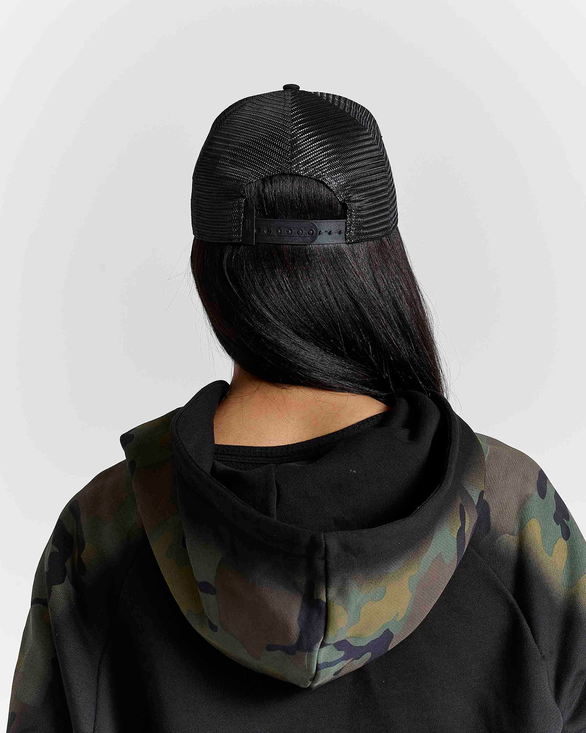 Displays a model wearing the black & grey 'Hoodrich' branded Nocturn Trucker Cap