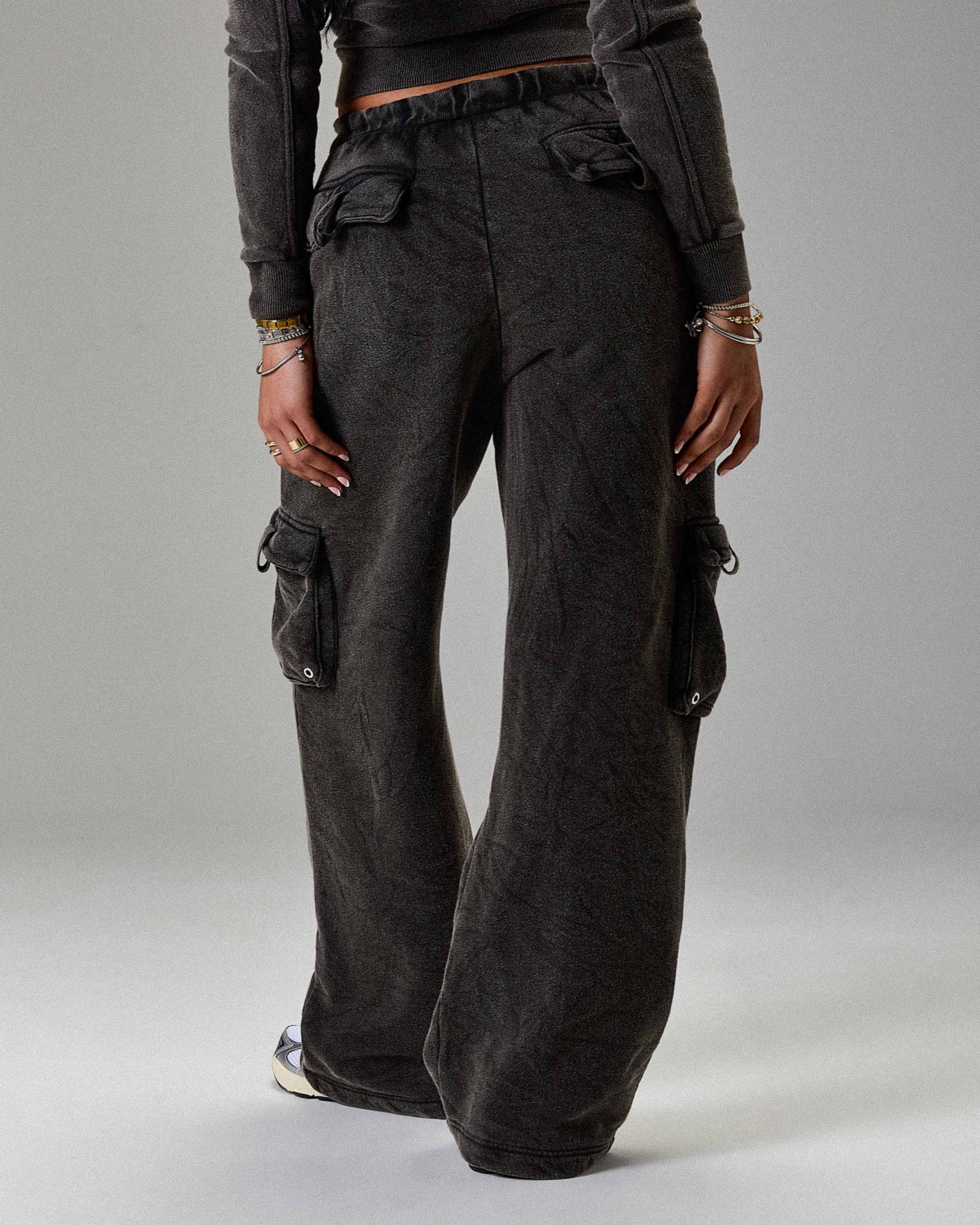 Displays a model wearing the Washed Black 'Hoodrich' branded women's The Winners Circle Token Full Tracksuit