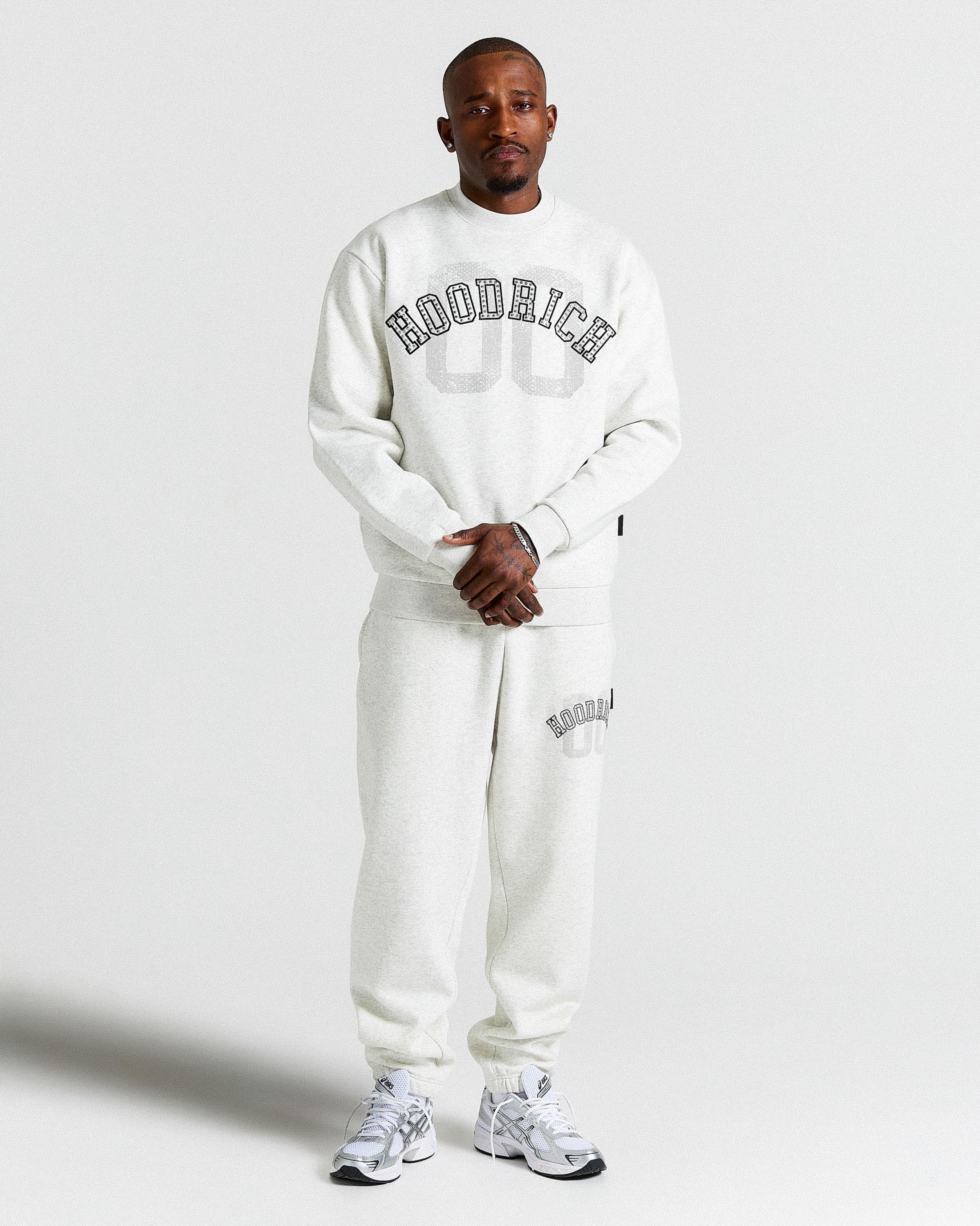 Displays a model wearing the Grey & Black 'Hoodrich' branded men's Rivet Full Tracksuit