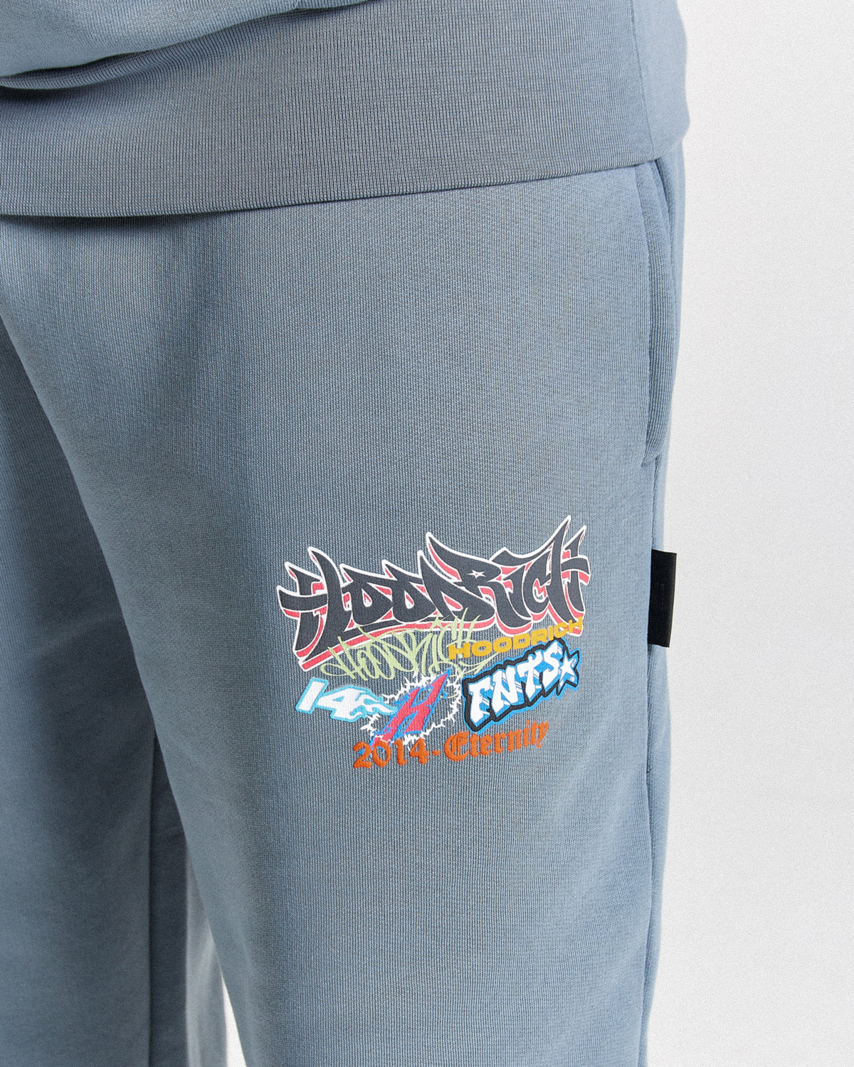 Displays a model wearing the Grey 'Hoodrich' branded men's Graff Rave Full Tracksuit featuring the hoodrich branding details