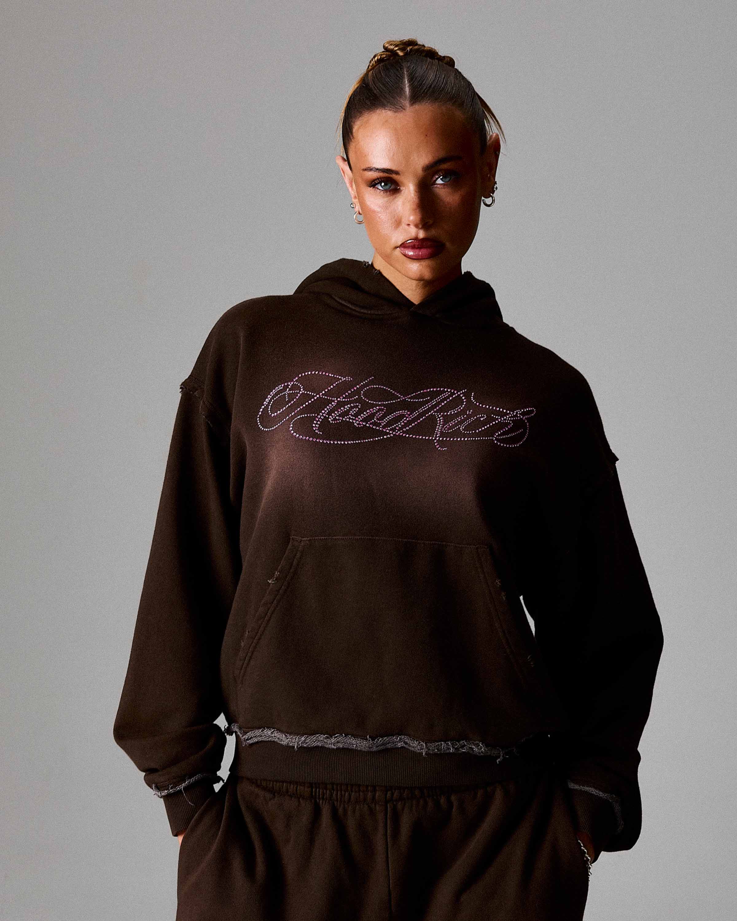Person wearing a black hoodie with 'Hoodrich' branding on a gray background