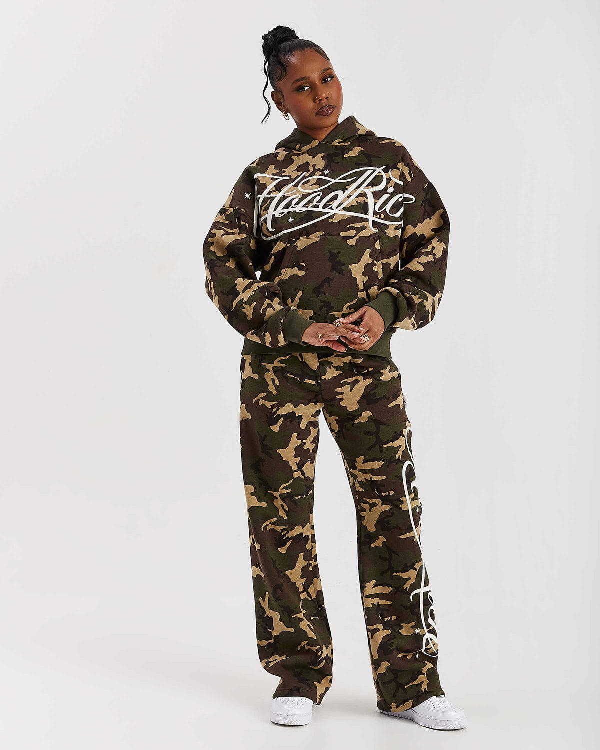 Displays a model wearing the Camo 'Hoodrich' branded women's Solace Full Tracksuit
