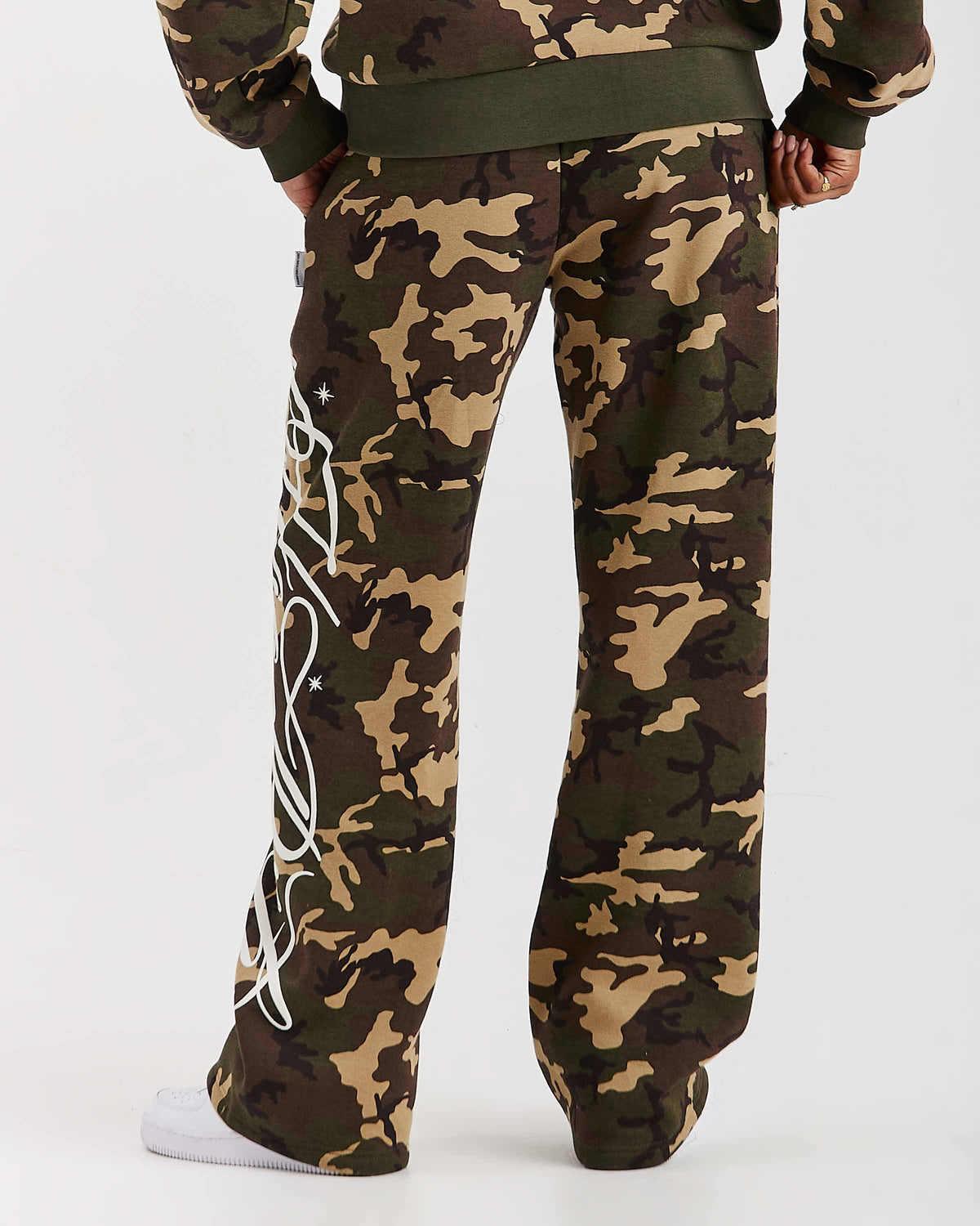 Displays a model wearing the Camo 'Hoodrich' branded women's Solace Full Tracksuit