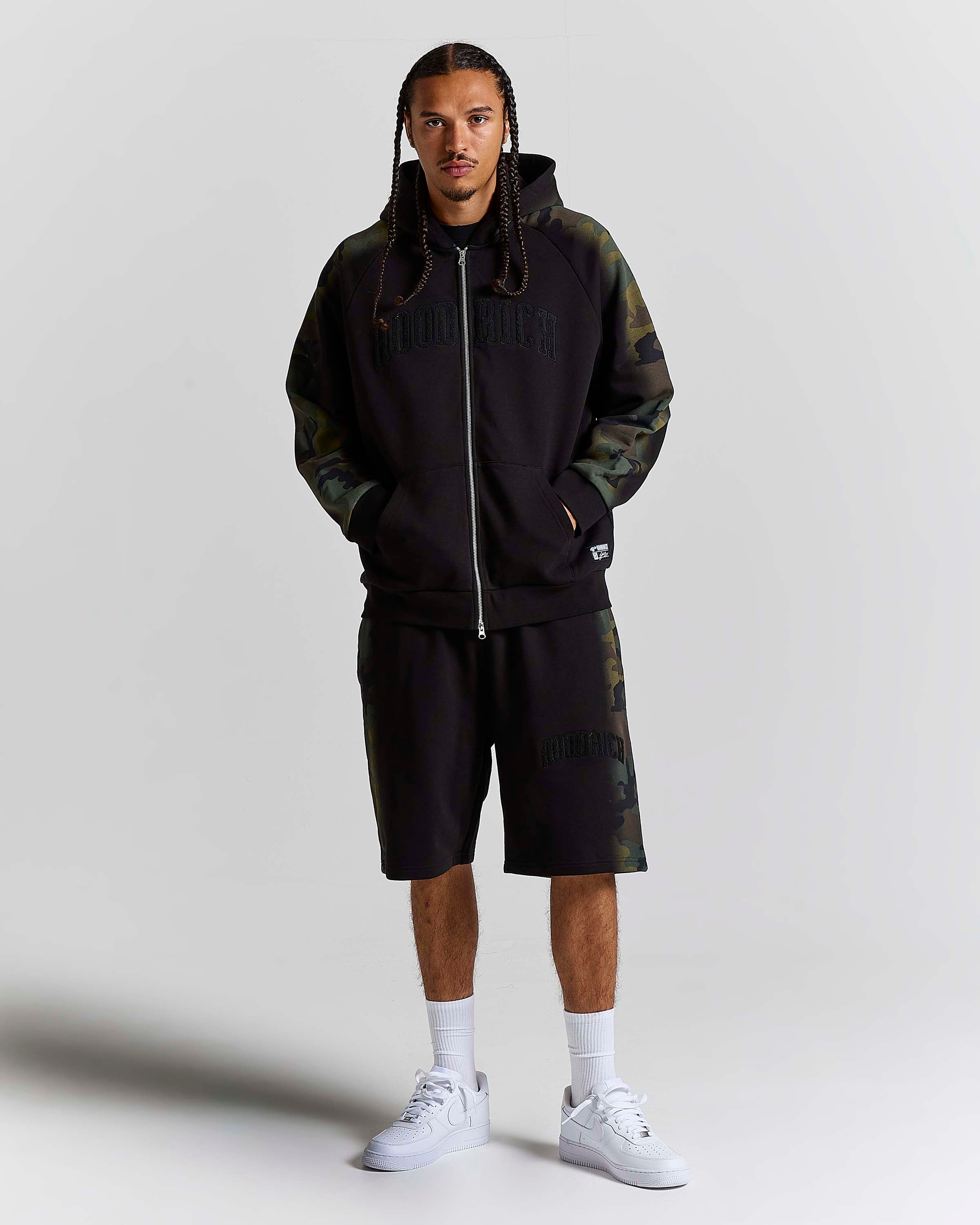 Displays a model wearing the Black Camo 'Hoodrich' branded men's Shade Matching Shorts Set 