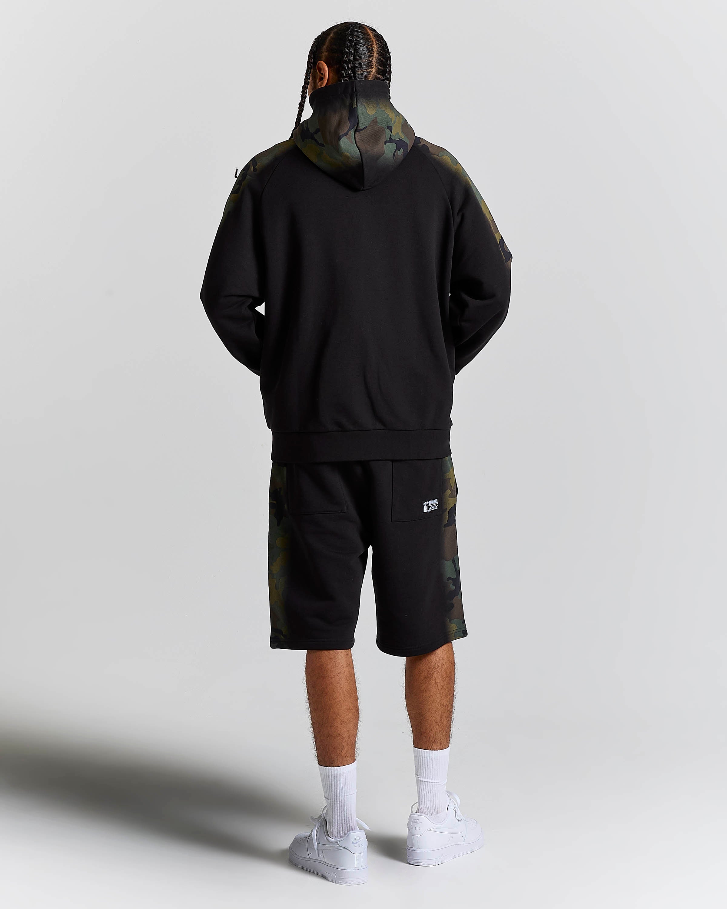 Displays a model wearing the Black Camo 'Hoodrich' branded men's Shade Matching Shorts Set 