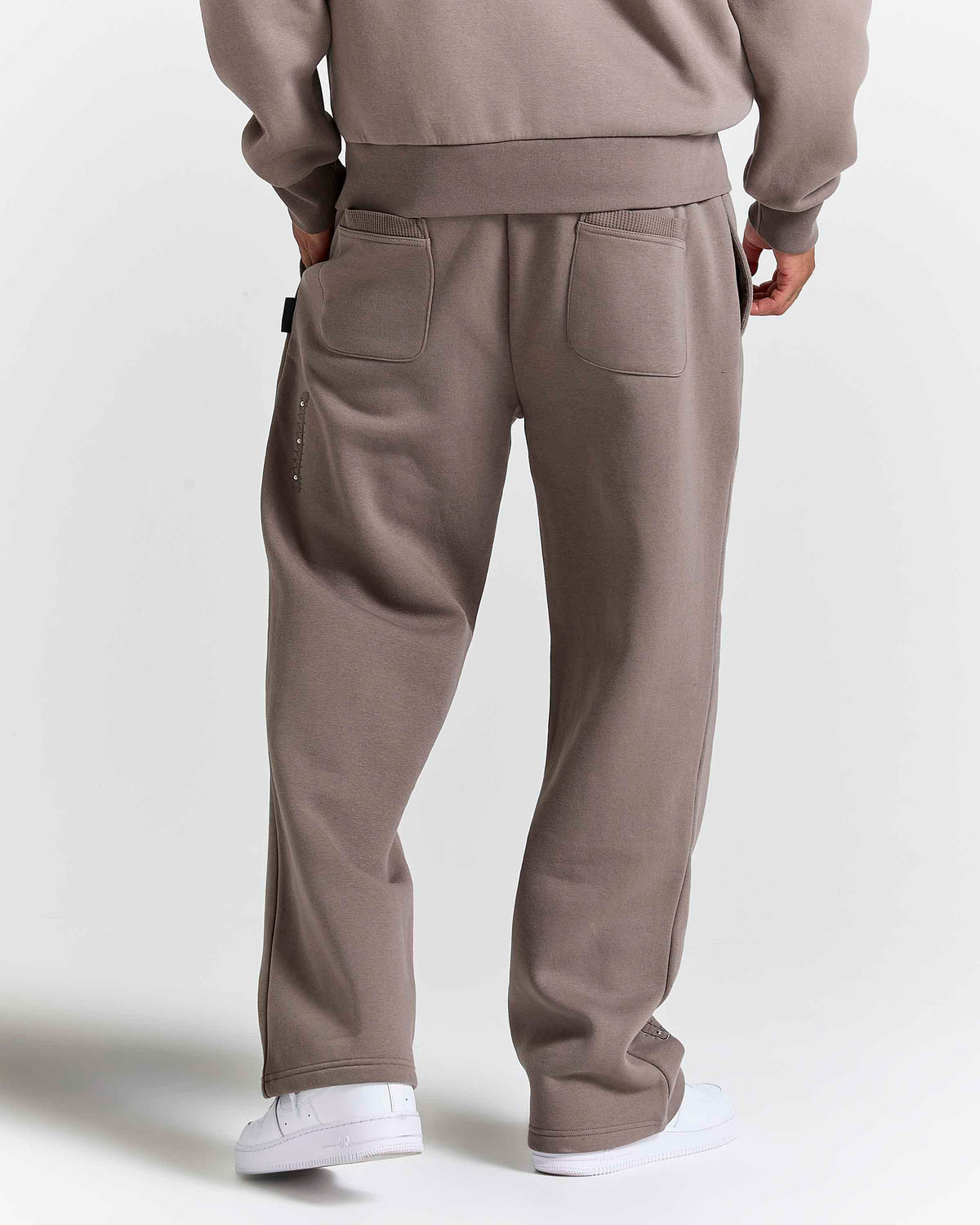 Displays a model wearing the Brown 'Hoodrich' branded men's Varso Studs Full Tracksuit 