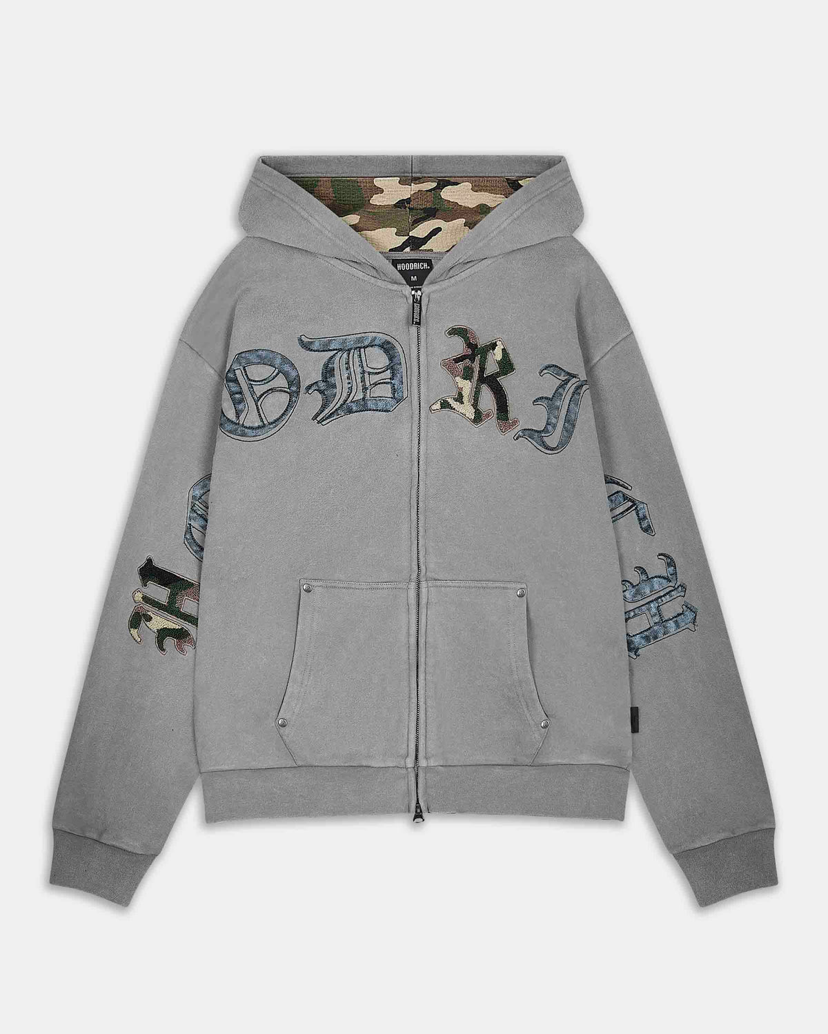A light gray zip-up hoodie featuring a camouflage hood lining, distressed gothic-style lettering across the chest and sleeves, and a front zipper.
