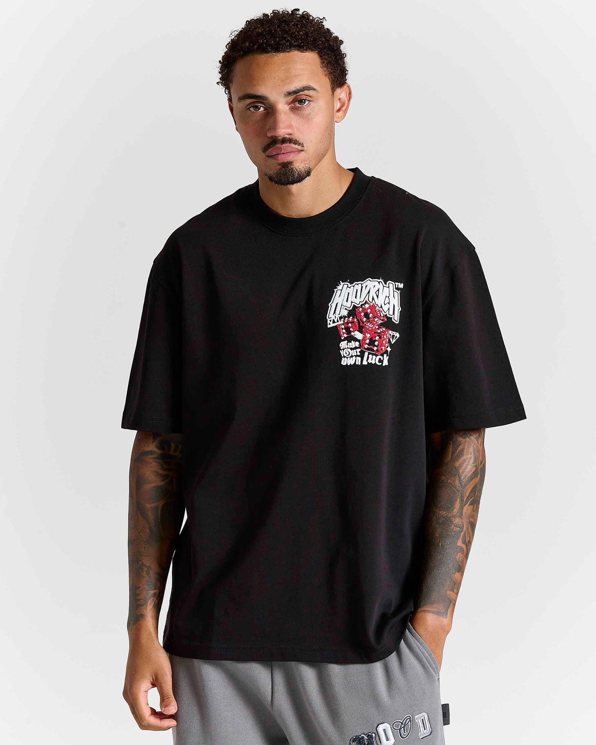 Displays a model wearing the Black 'Hoodrich' branded Fortune Oversized T-Shirt 