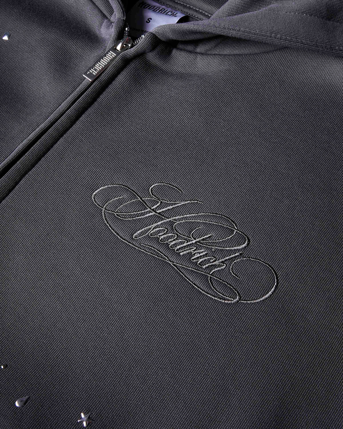 Displays the grey 'Hoodrich' branded women's Clash Full Tracksuit featuring the details on the hoodrich branding 