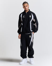 Male model wearing a black tracksuit with white accents on a light gray background