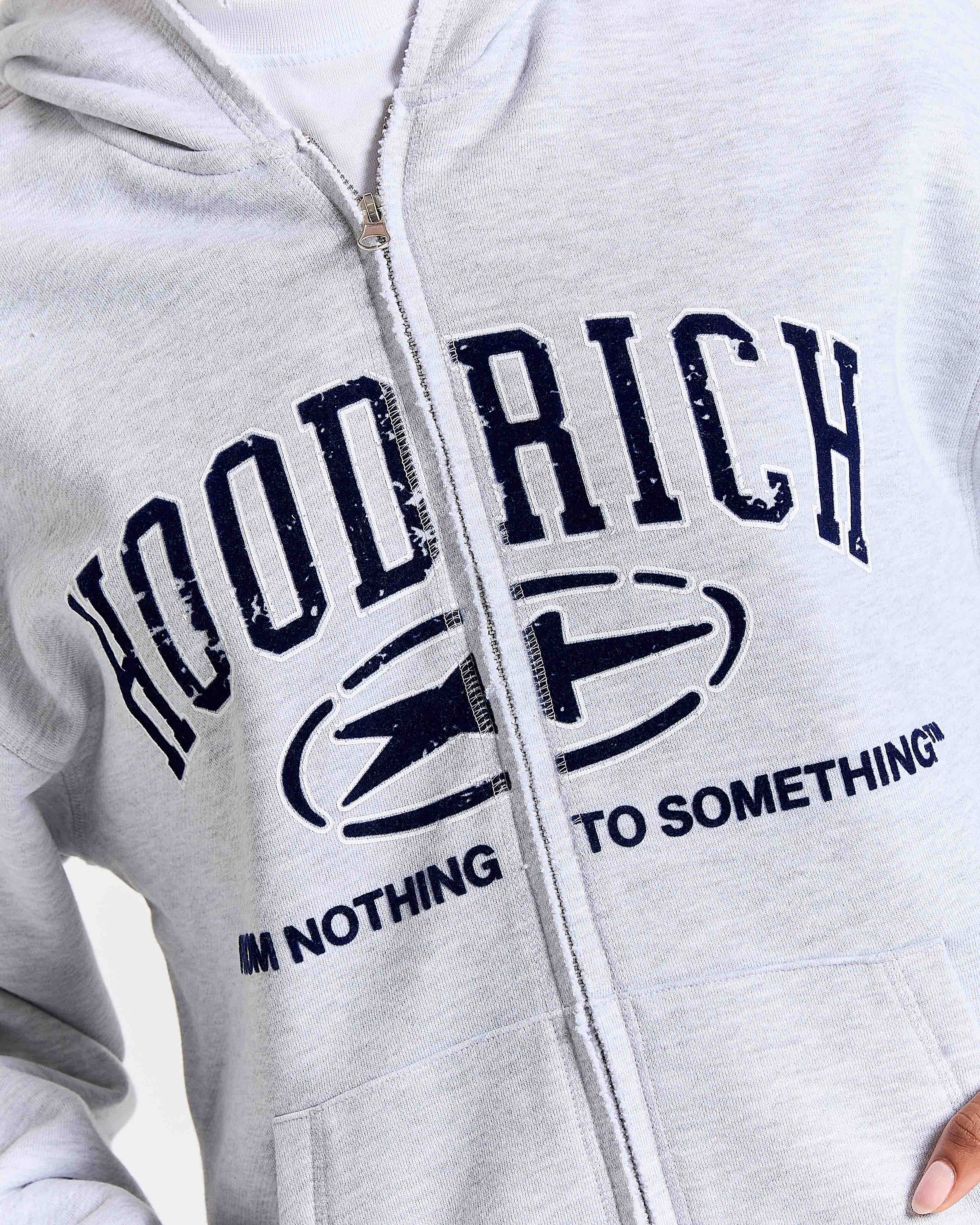 Gray hoodie with 'Hood Rich, I'm Nothing to Something' text and logo on a white background