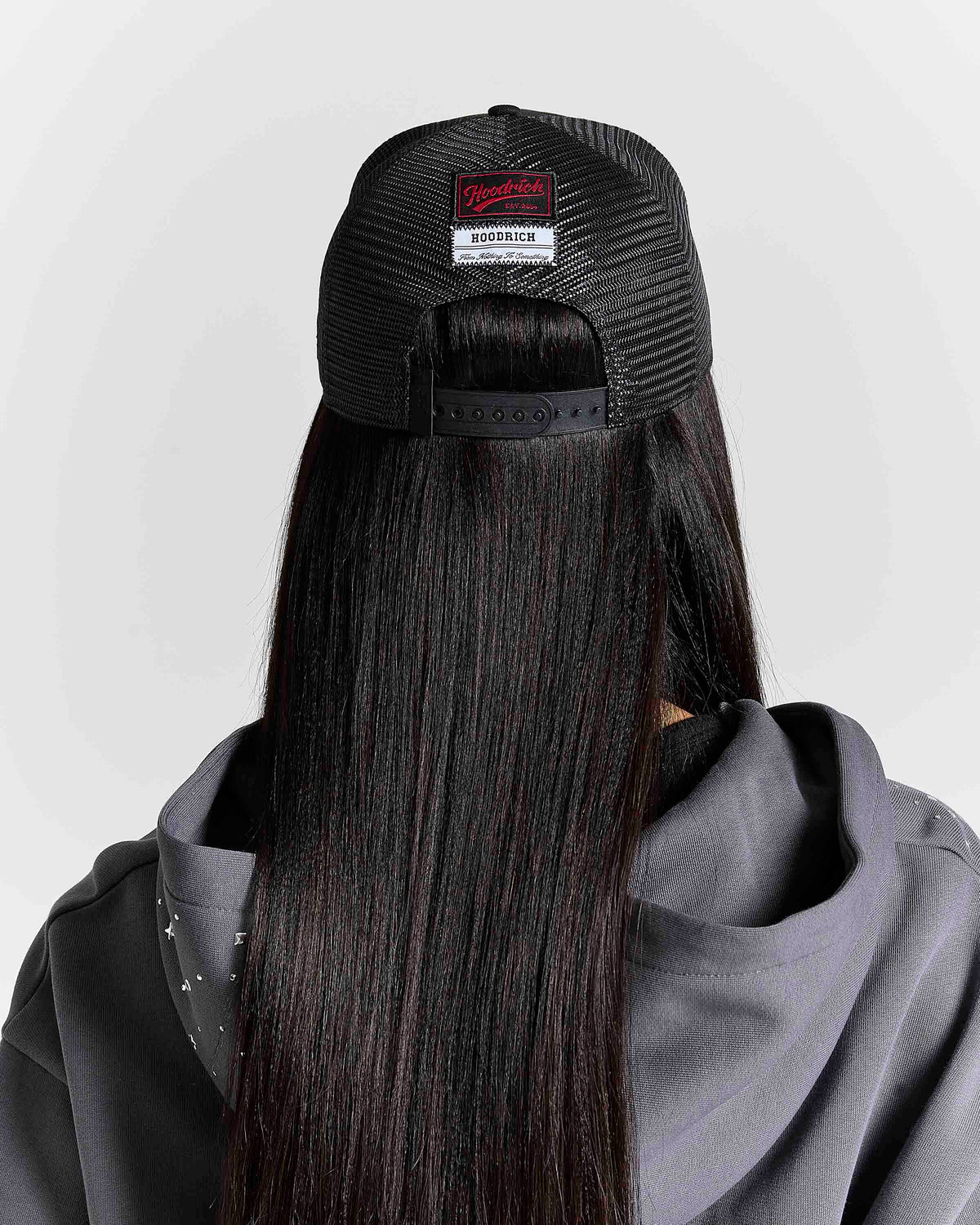 Displays a model wearing the black 'hoodrich' branded Stade 5 Panel Cap