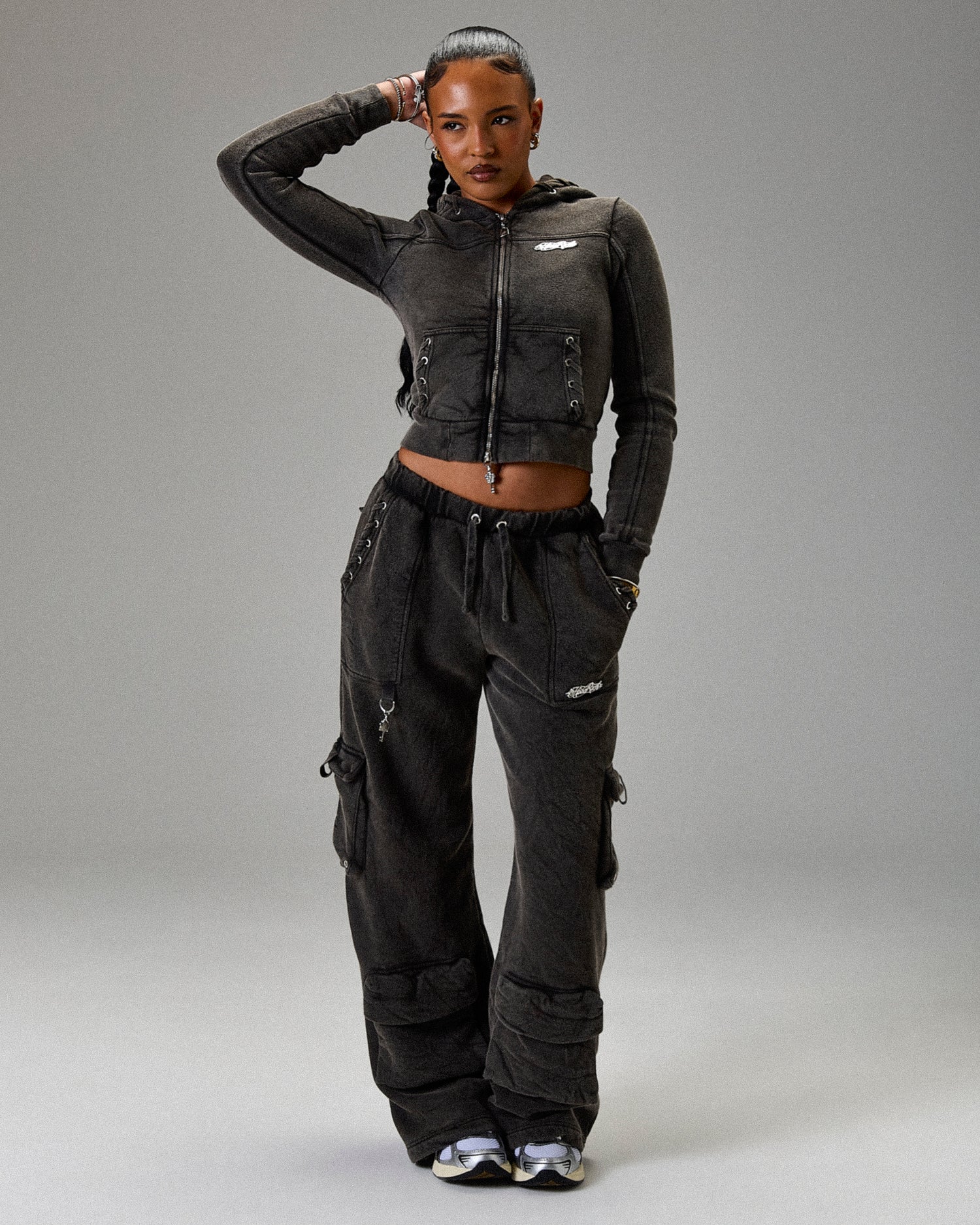 Person wearing a black outfit with a jacket and pants on a gray background