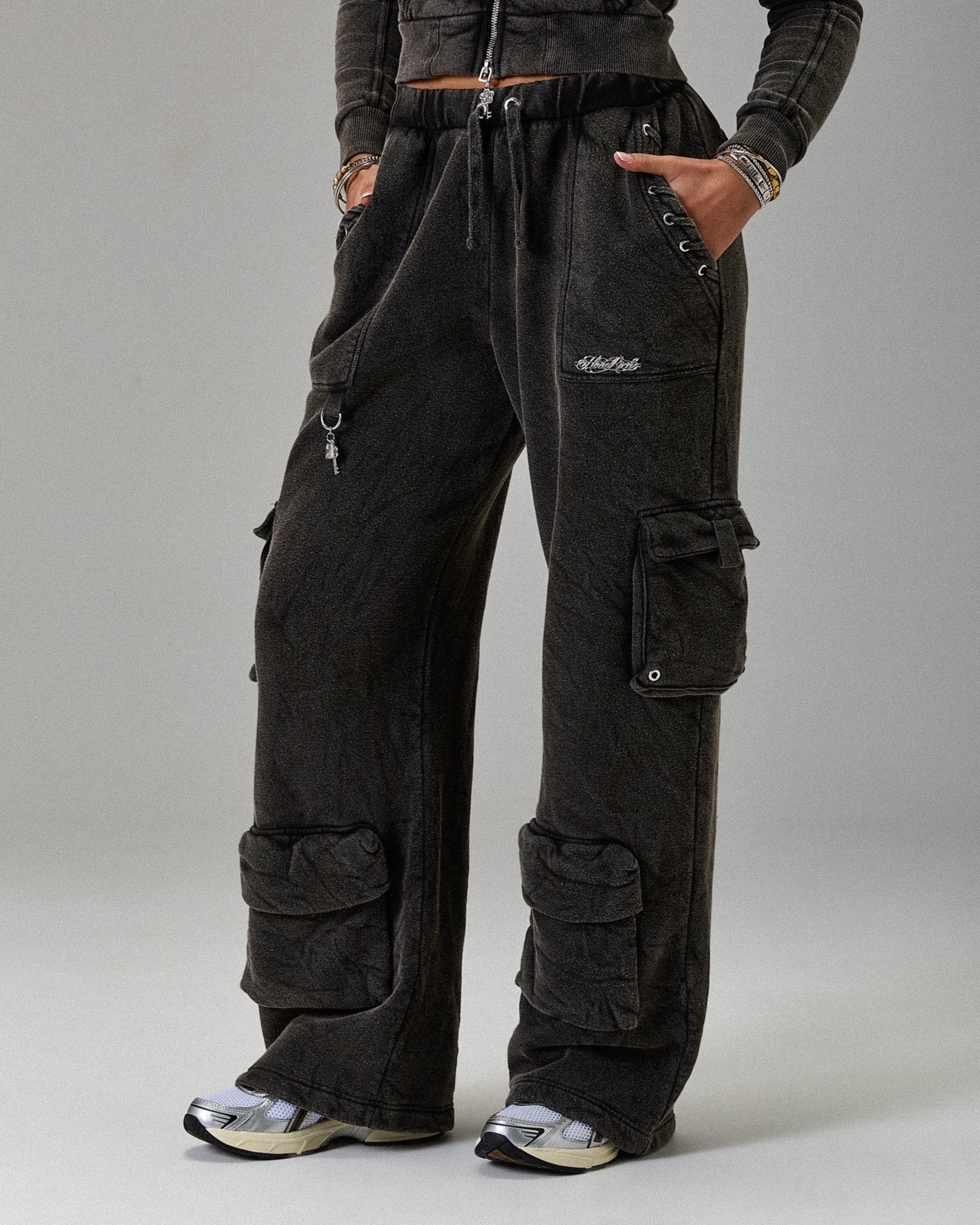 Person wearing black cargo pants on a gray background