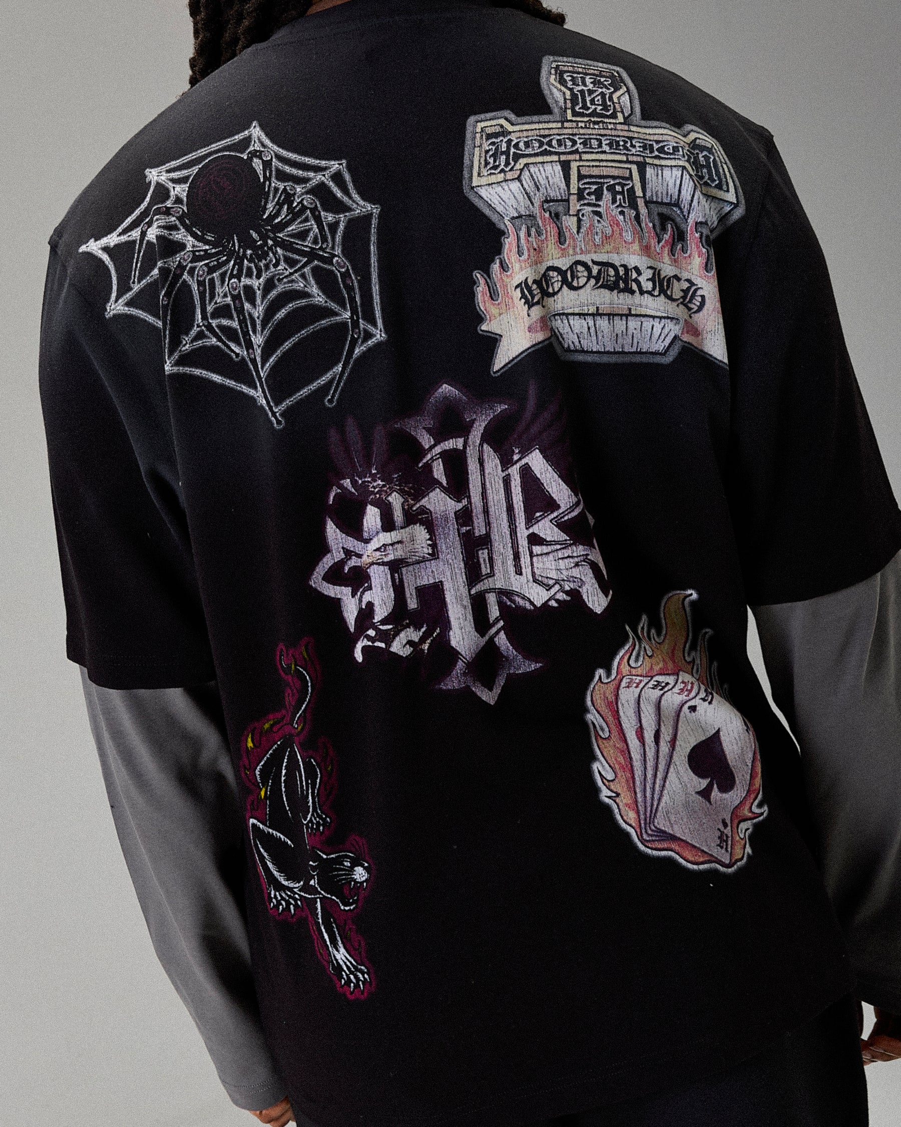 Black t-shirt with various embroidered designs on a plain background