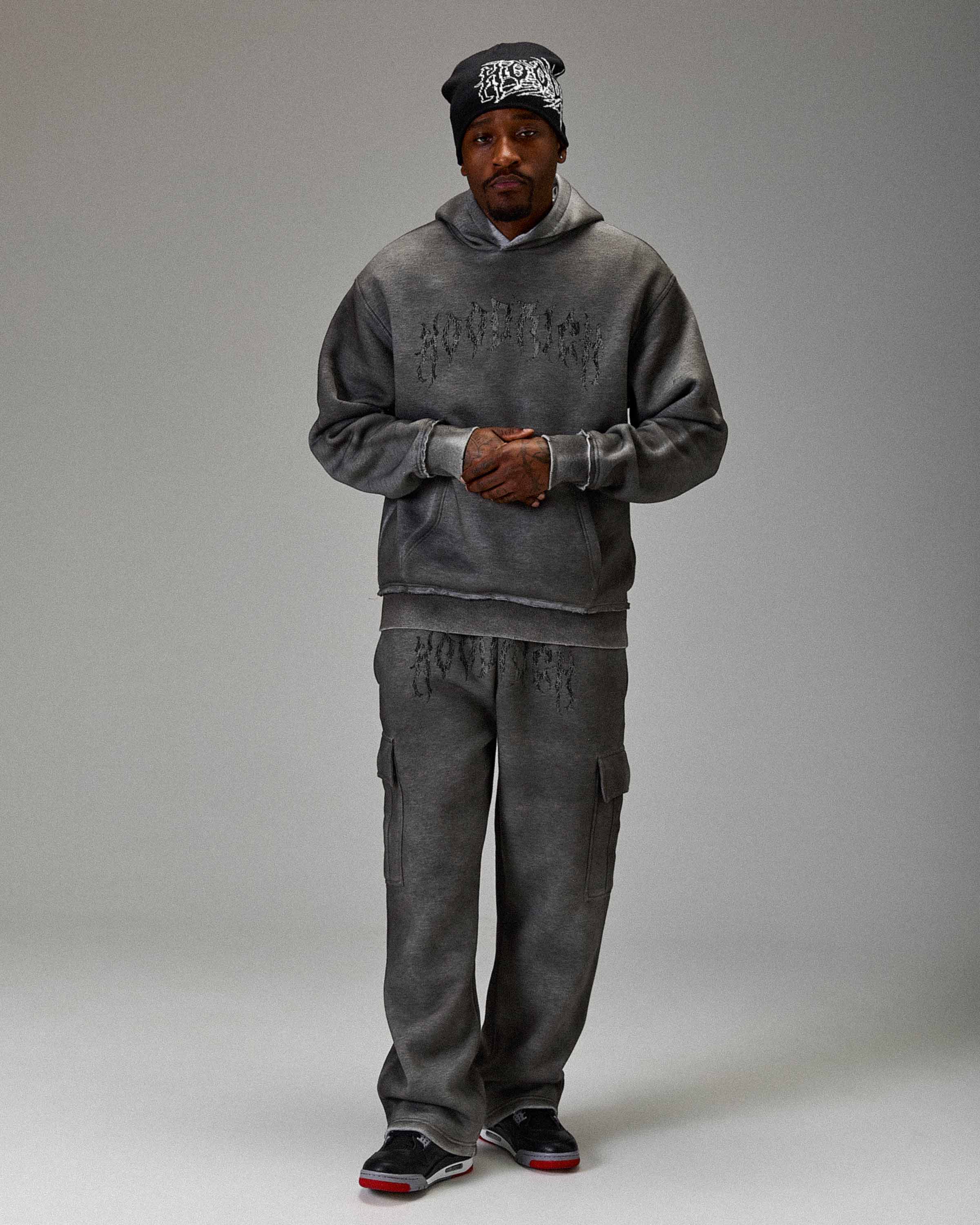 Displays a model wearing the Grey 'Hoodrich' branded men's The Winner's Circle Hazy Full Tracksuit 