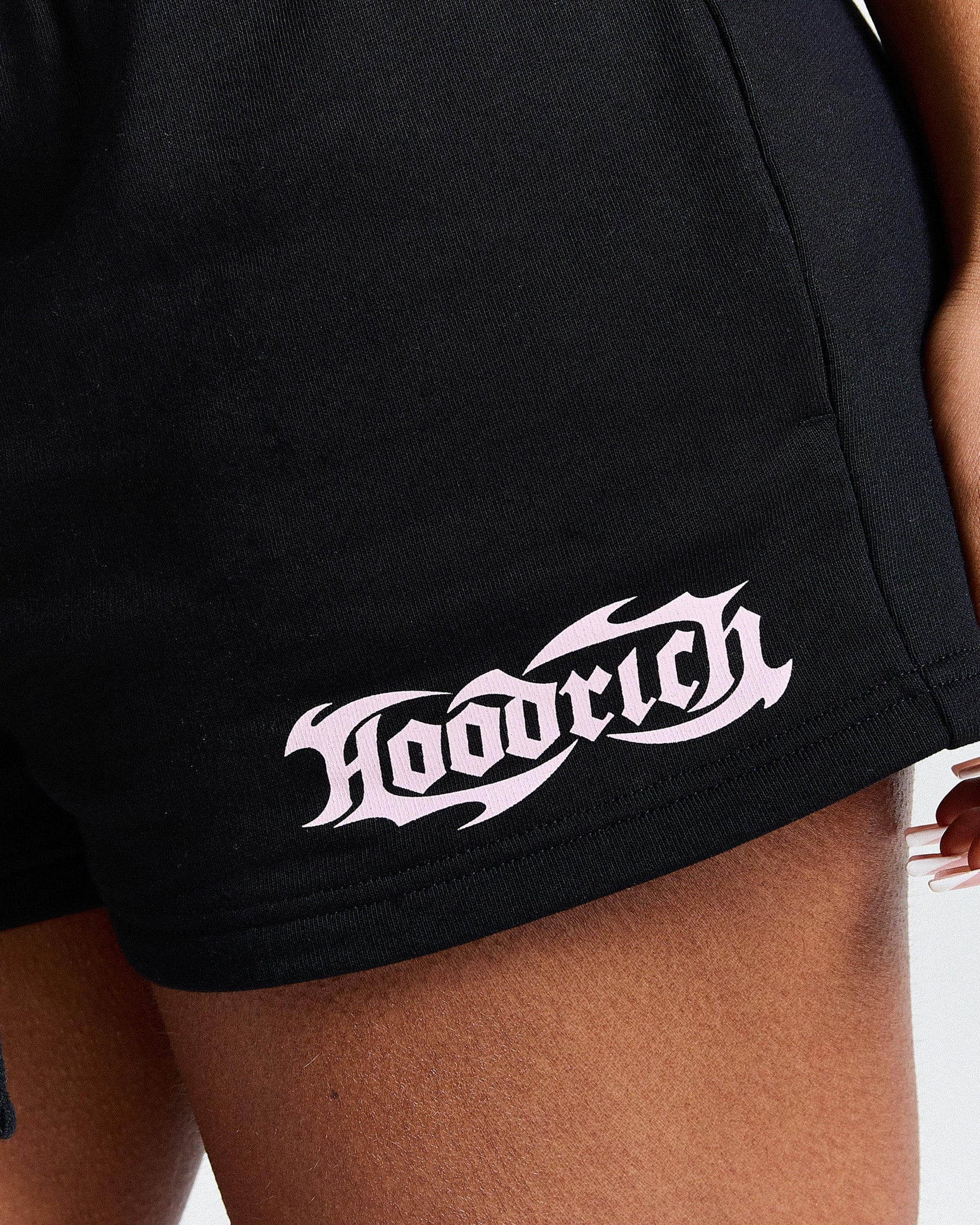 Black shorts with a white logo on a person wearing them.