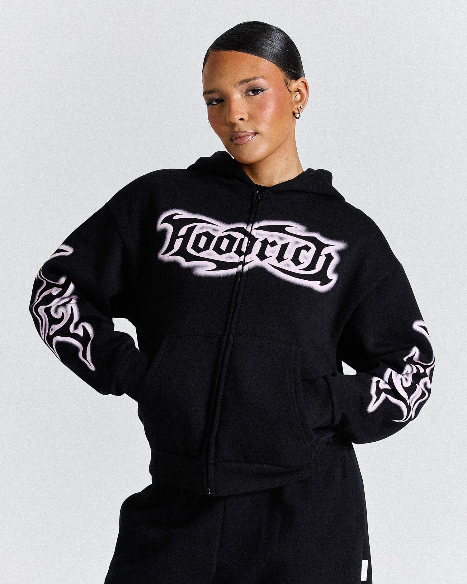 Person wearing a black hoodie with 'HOODRICH' branding on a light gray background