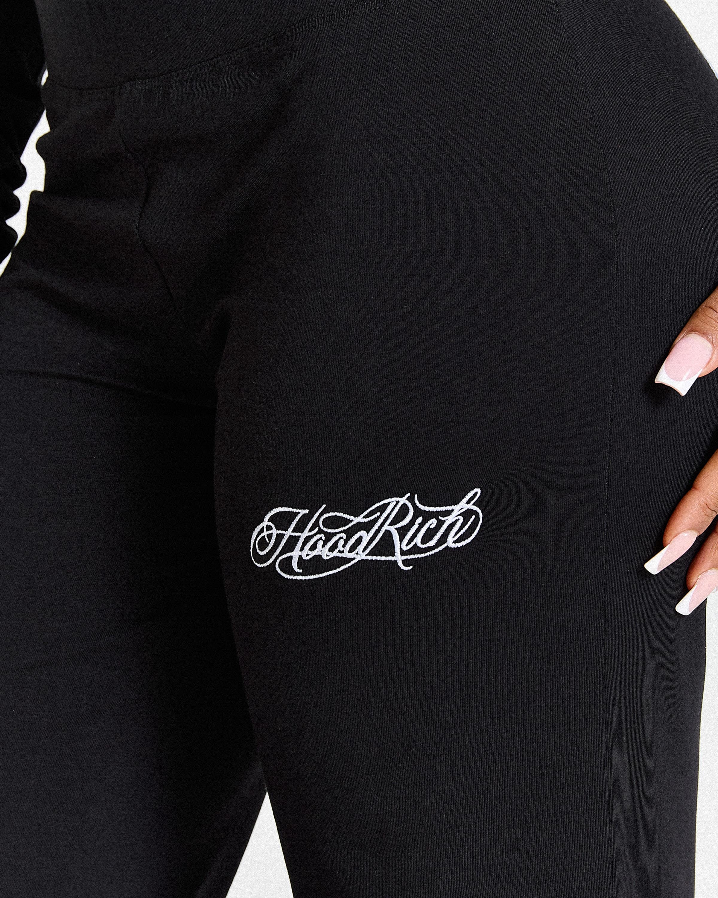Black pants with 'Hoodrich' logo on a white background