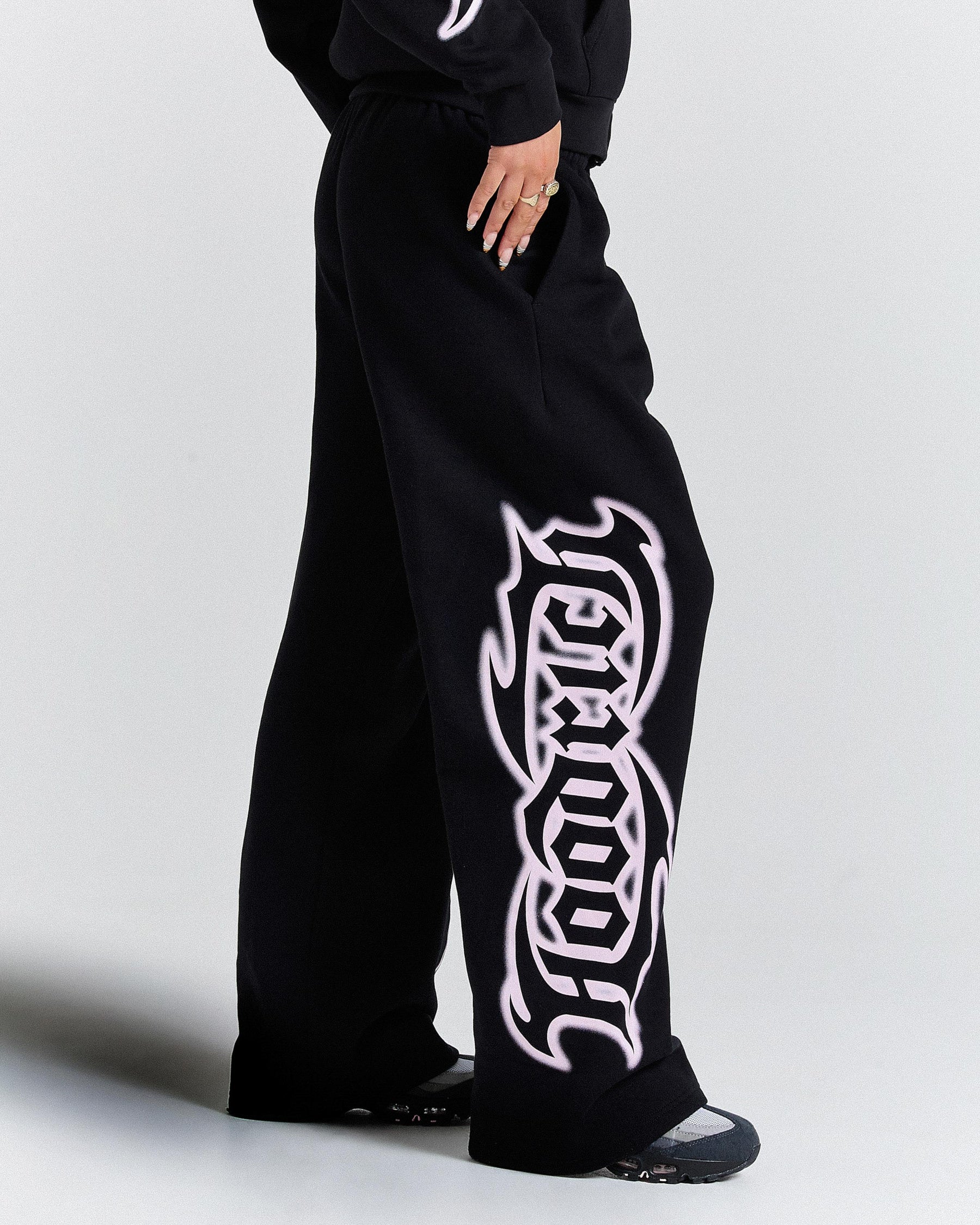 Black sweatpants with white logo on a plain background