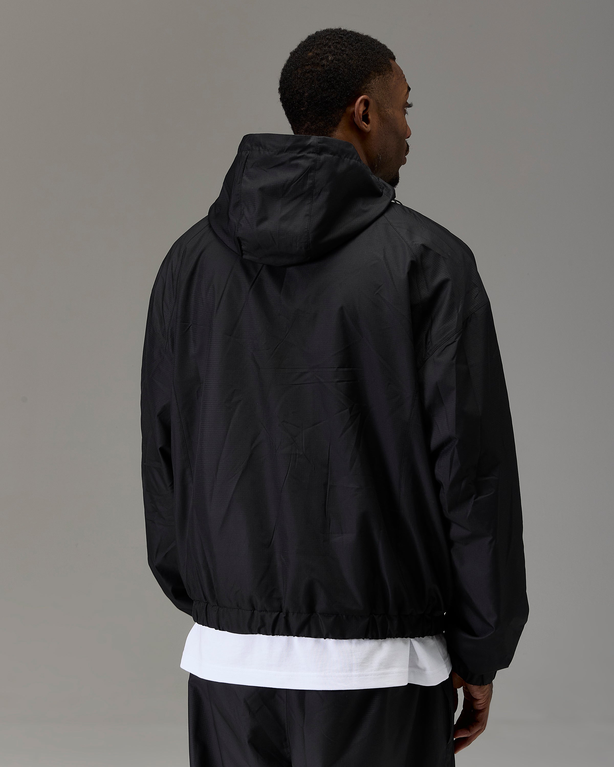 Displays a model wearing the Black 'Hoodrich' branded Men's The Winner's Circle Ripstop Woven Full Tracksuit