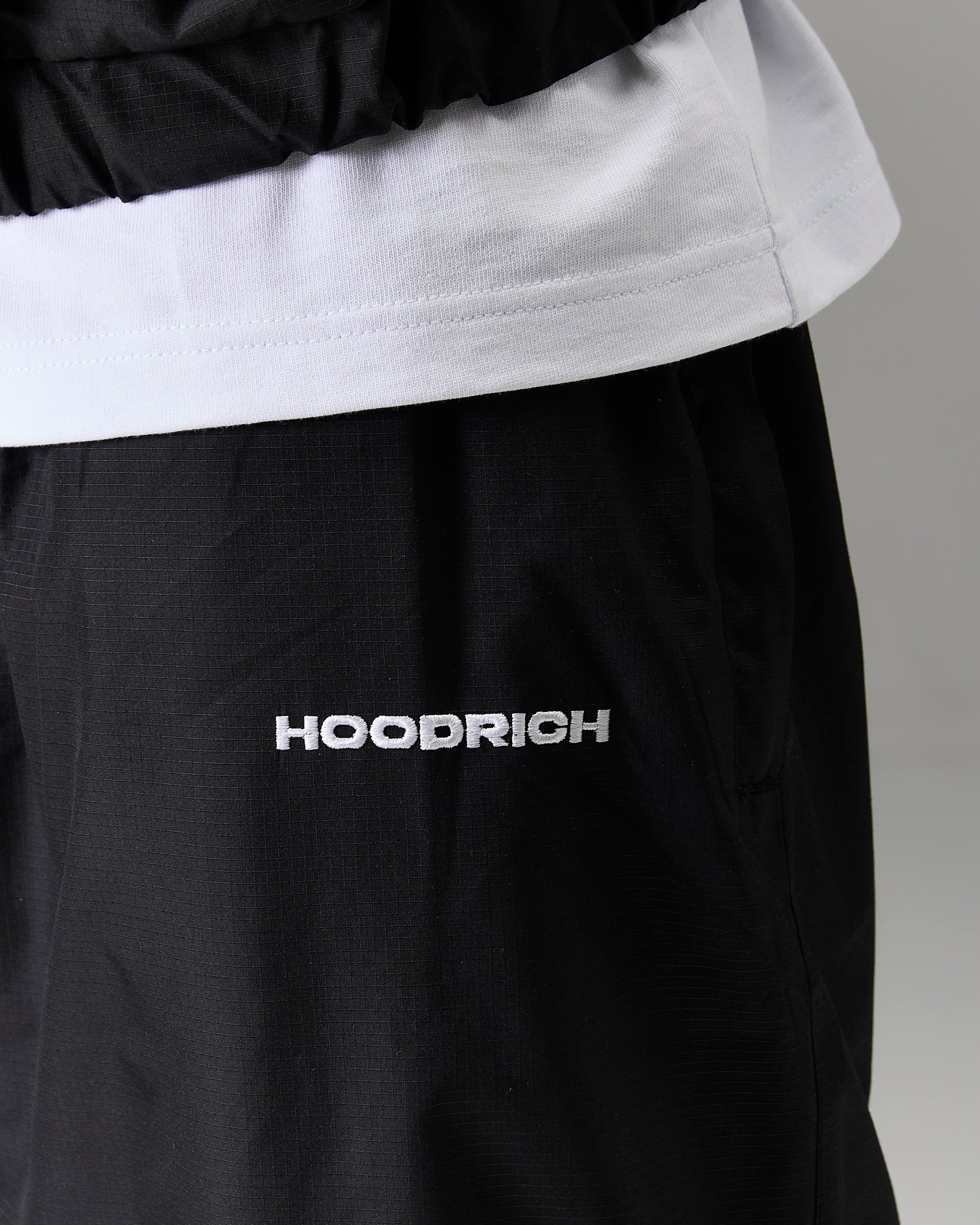 Displays a model wearing the Black 'Hoodrich' branded Men's The Winner's Circle Ripstop Woven Full Tracksuit