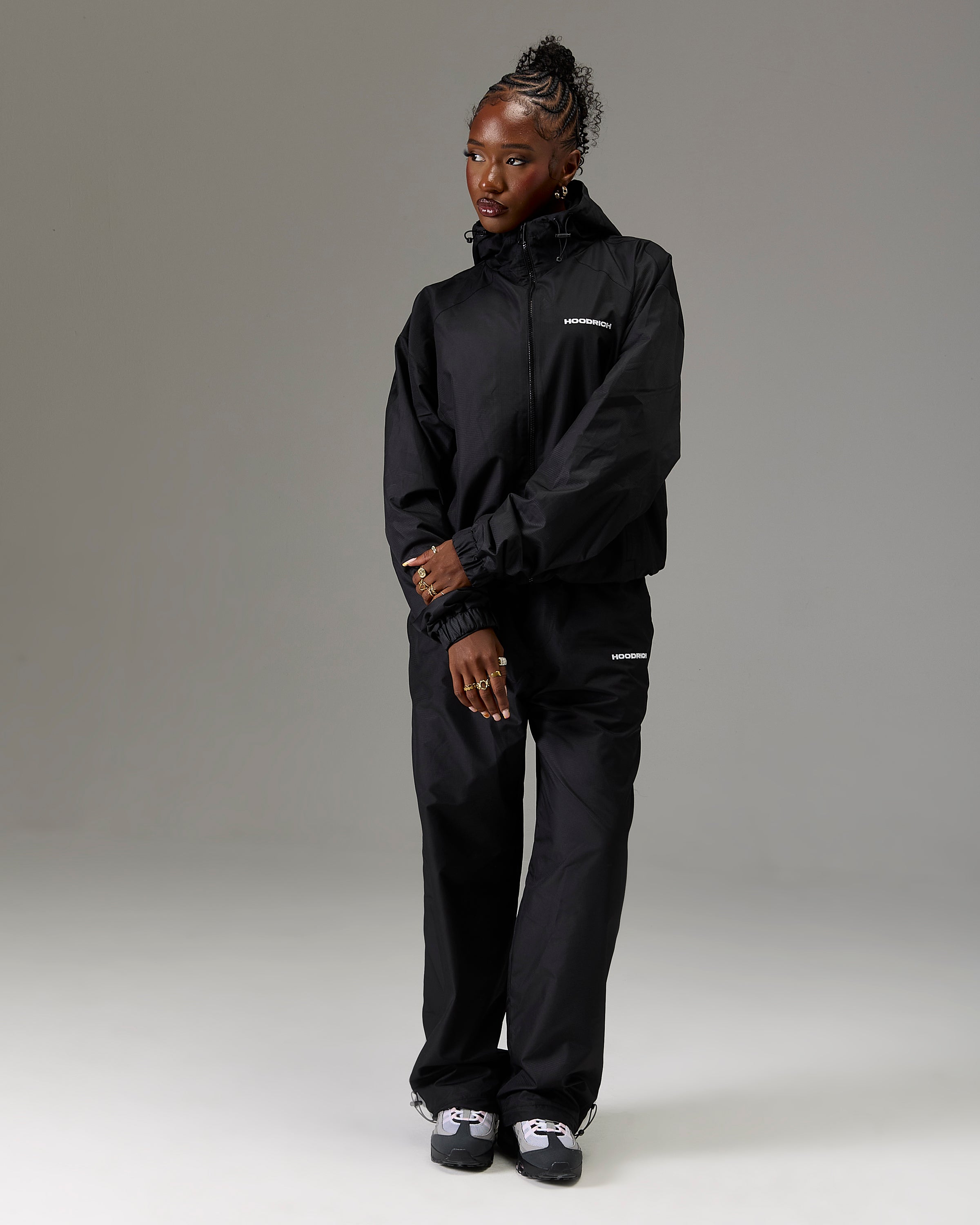 Displays a model wearing the Black 'Hoodrich' branded women's The Winner's Circle Ripstop Woven Full Tracksuit