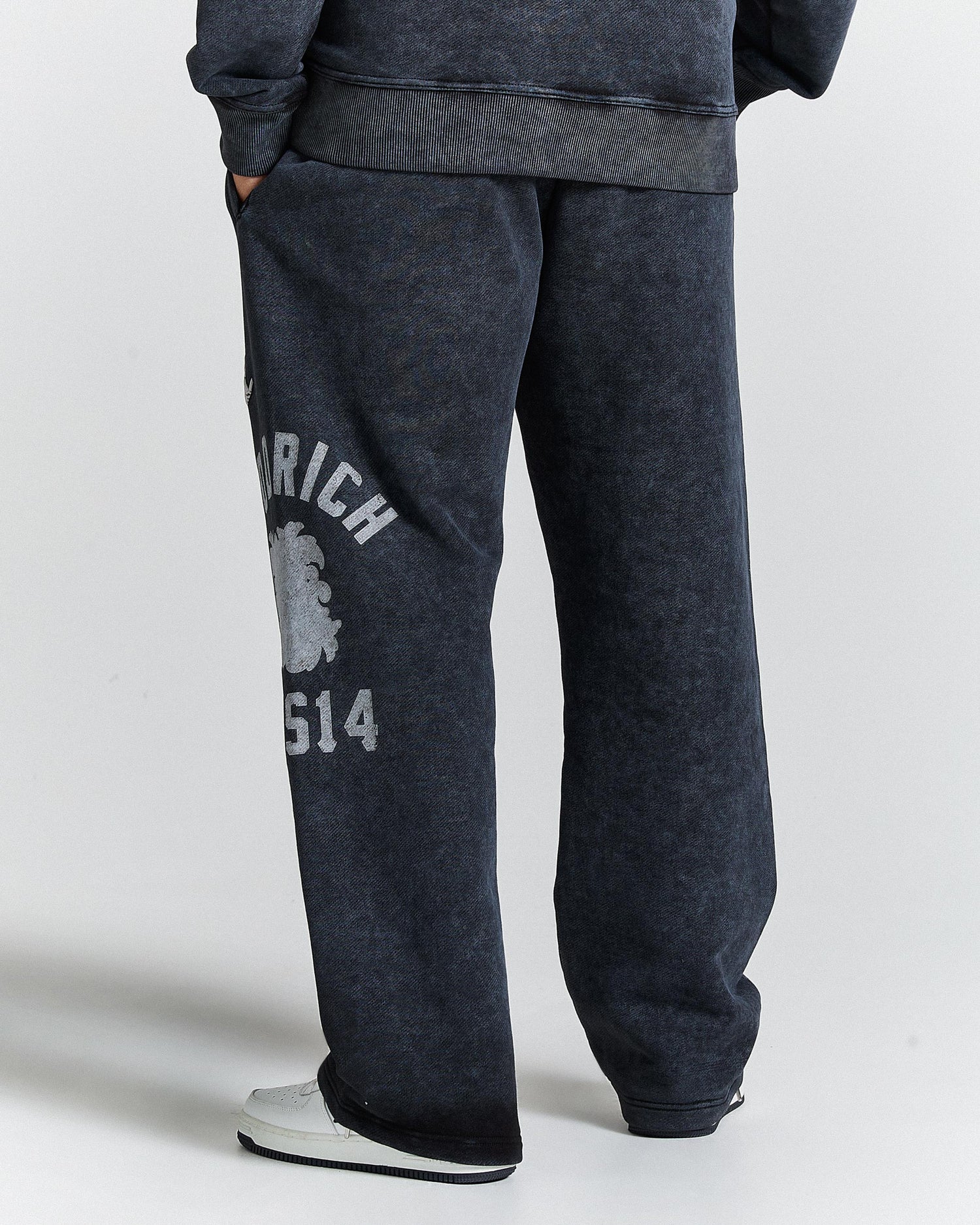 Dark gray sweatpants with a logo and text on a white background