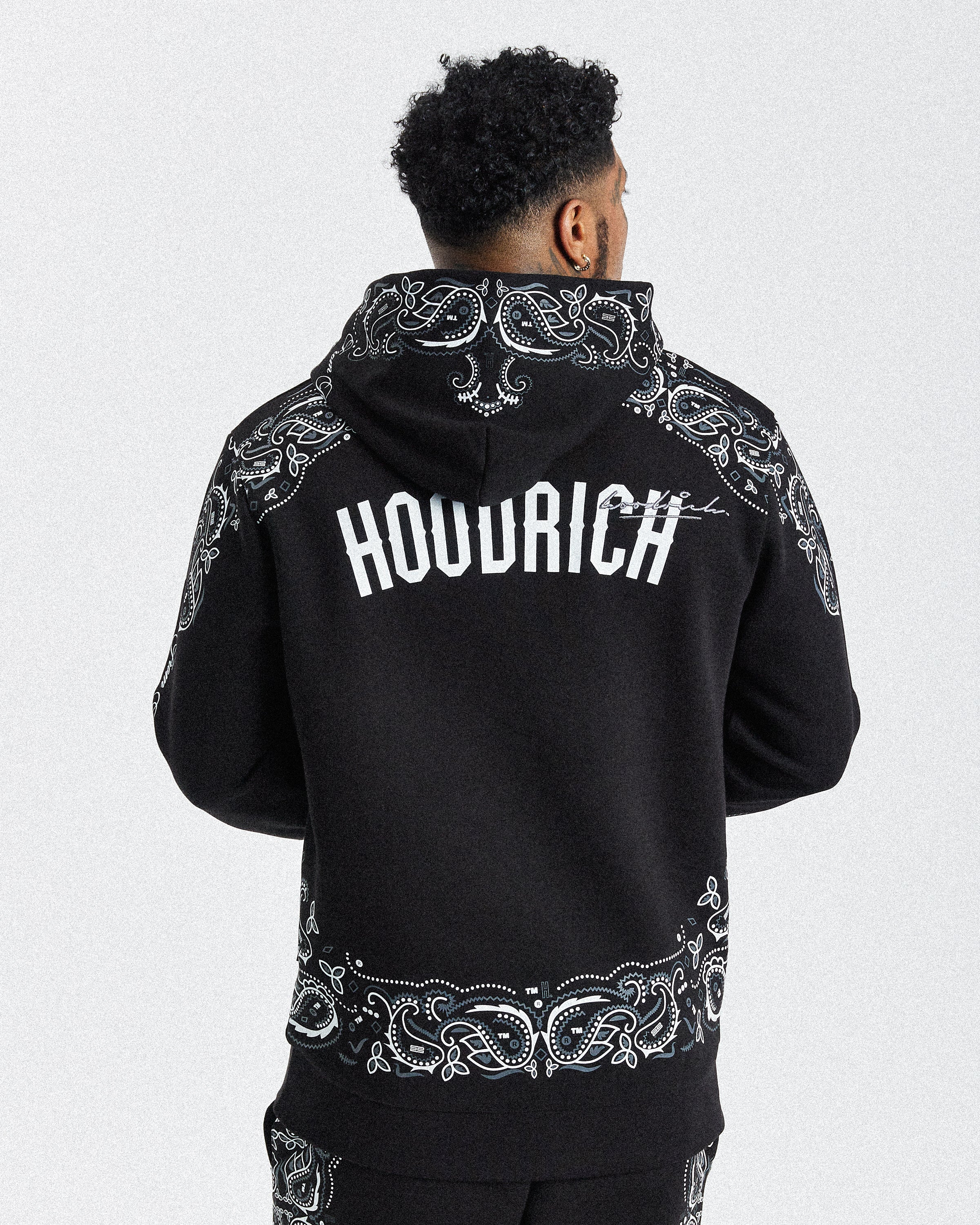Displays a model wearing the black 'hoodrich' branded men's Motif Full Tracksuit 