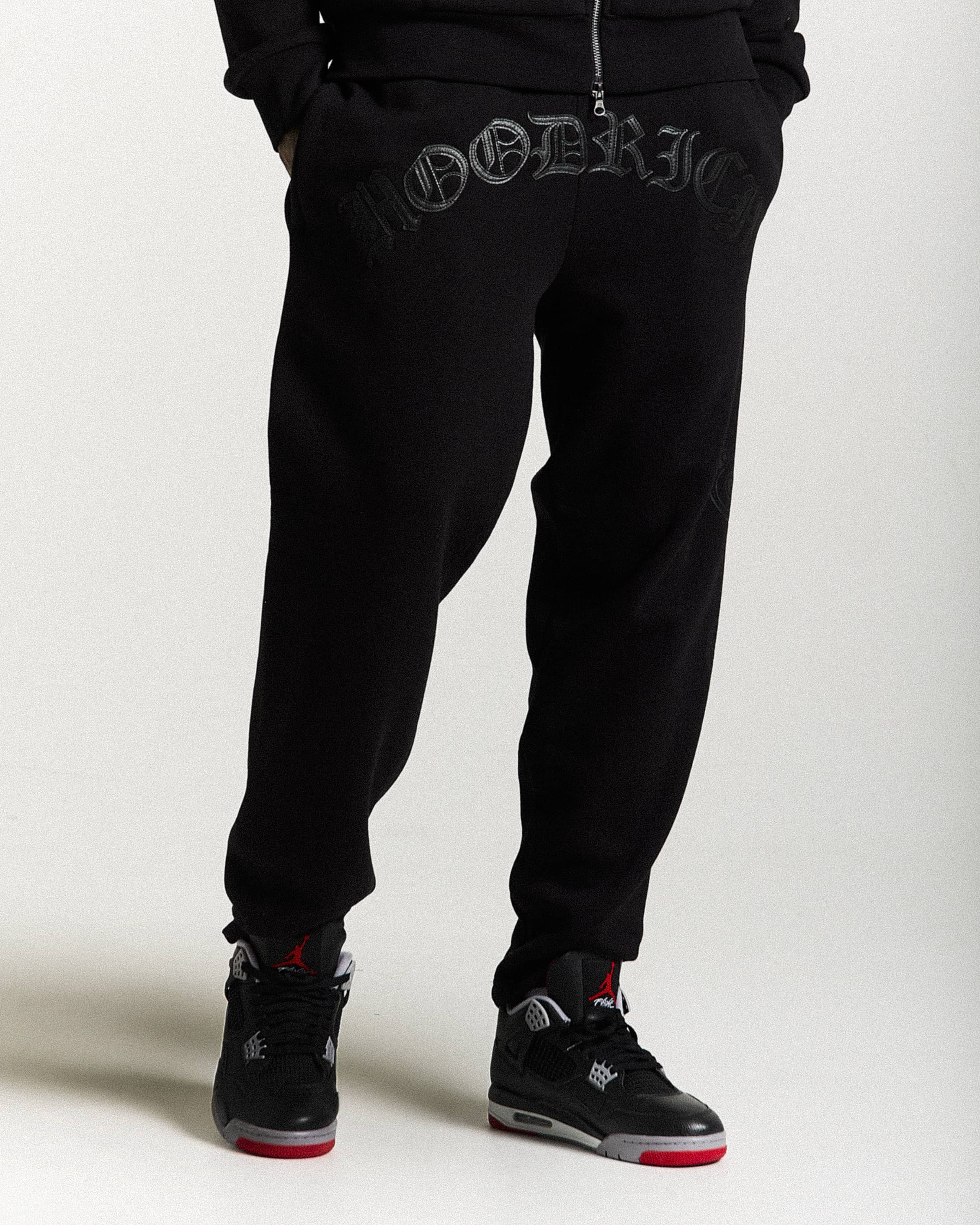 Black jogger pants with brand logo on a white background